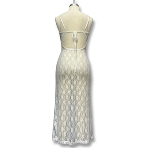 Détail d'une robe longue en dentelle blanche avec dos nu à lacets et motif floral
