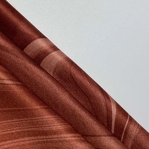 Macro shot of high-quality red-brown textile fabric with twill texture and silky sheen