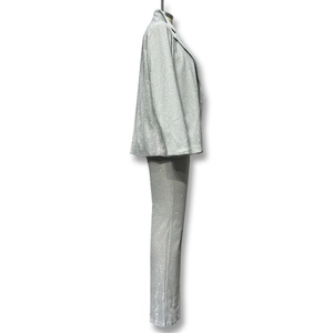 Dettaglio del tessuto con paillettes argento su completo blazer e pantaloni effetto metallico