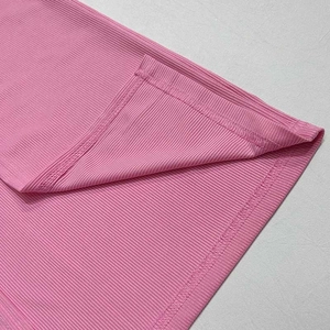 Detailed macro view of pink ribbed fabric texture and fine stitching for two-piece set