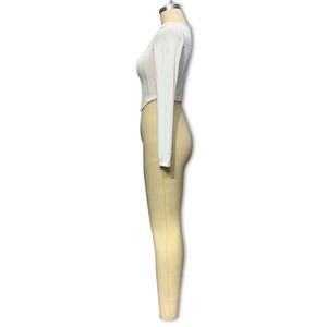 Detailaufnahme von weißem geripptem Langarm-U-Ausschnitt-Oberteil und khakifarbenen Leggings