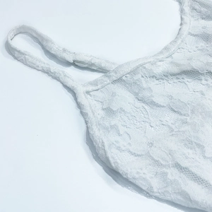 Gros plan sur la robe en dentelle blanche avec texture résille et bretelles