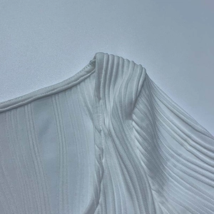 Detail von weißem Rippstrickstoff mit U-Ausschnitt und feiner vertikaler Textur