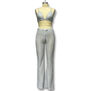 Dettaglio del set due pezzi con paillettes argento con bralette a V e pantaloni svasati