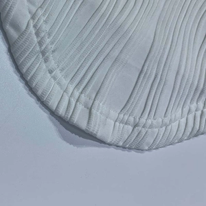 Detailaufnahme des weißen Rippstrickgewebes und des geschwungenen Saums mit Doppelnaht