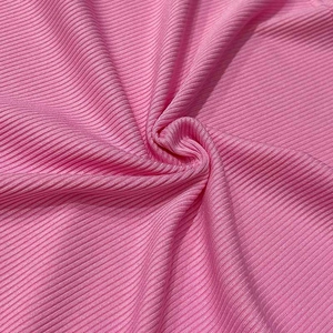 Macro shot of pink ribbed knit fabric showing detailed vertical texture and soft elasticity