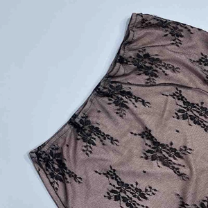 Dettaglio della maglia in pizzo floreale nero con fodera color carne per vestito