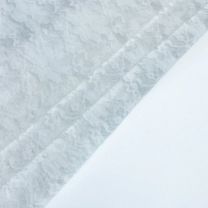 Gros plan détaillé montrant le motif floral complexe et la texture transparente du tissu blanc