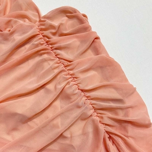 Détail du tissu en maille corail montrant des couches plissées et une texture fine
