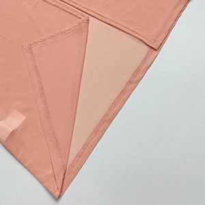 Détail macro de la couture haute densité sur le tissu en mesh rose pêche translucide