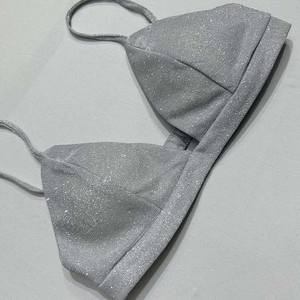 Dettaglio del top bikini argento glitterato con trama metallica e spalline sottili
