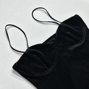 Detailopname van zwarte corduroy tubetop met fijne textuur en dunne spaghettibandjes