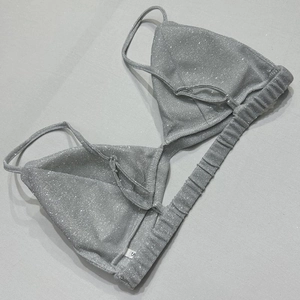 Dettaglio del top bikini con paillettes argento con bordo elastico ed etichetta taglia S