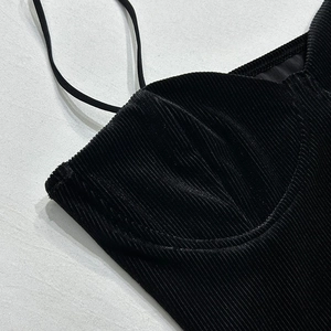Detail van de zwarte corduroy jurk met geribbelde textuur en dunne spaghettibandjes