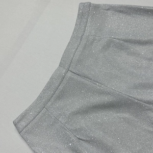 Dettaglio macro delle paillettes argentate ad alta densità sulla vita dei pantaloni