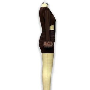 Dettaglio dell'abito corto marrone scuro con polsini in piuma e arricciatura laterale