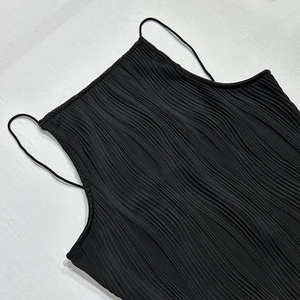 Gros plan détaillé sur le tissu plissé noir texturé d'une robe nuisette slim élégante