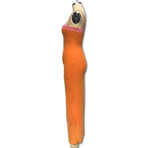 Détail de la dentelle rose sur la robe longue moulante orange à fines bretelles