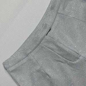 Dettaglio della trama del tessuto con paillettes argento e cuciture del completo a tre pezzi