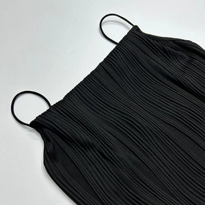 Gros plan sur la texture du tissu noir côtelé d'un débardeur à fines bretelles