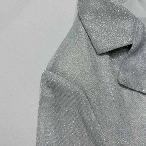 Dettaglio del tessuto glitterato argento sul bavero della giacca con trama lucida