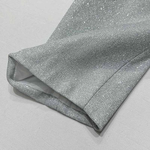 Dettaglio del tessuto con paillettes argento e cuciture precise del completo a tre pezzi