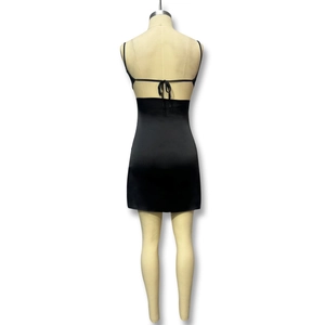 Détail du design dos nu et des fines brides à lacets sur cette mini robe en satin noir chic