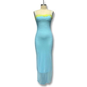 Détail de la robe moulante bleu clair avec dentelle jaune et ourlet en mesh transparent