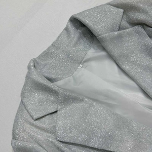 Dettaglio del blazer argento con paillettes, revers classici ed etichetta taglia S
