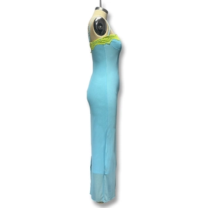Détail d'une robe moulante bleu clair avec bordure en dentelle jaune fluo et fines bretelles