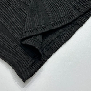 Détail de la texture en maille côtelée noire et des coutures de précision d'une robe d'été