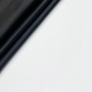 Gros plan sur un tissu en satin noir avec plis élégants et texture luxueuse
