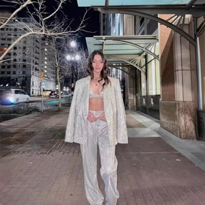 Completo tre pezzi di paillettes argento con blazer, top corto e pantaloni a gamba larga