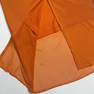 Détail de l'ourlet de la robe orange avec maille fine et doublure intérieure assortie