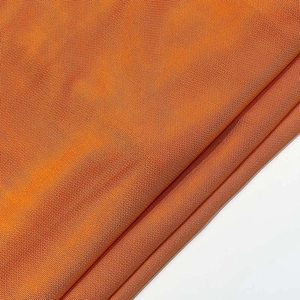 Gros plan sur un tissu en maille nid d'abeille orange vif avec texture respirante