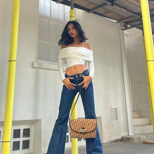 Sexy crop top met lange mouwen en blote schouders gecombineerd met flared jeans denim