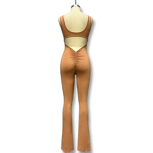 Detail van de geplooide billen en U-vormige ruguitsnijding op de bruine yoga jumpsuit