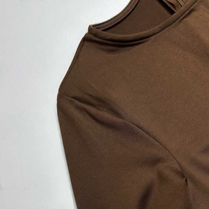 Close-up of the round neckline and seam detail of this coffee brown long sleeve bodysuit