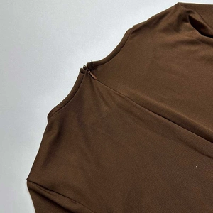 Detail view of the back invisible zipper closure on this brown long-sleeve bodysuit
