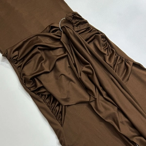 Detailed view of dark brown silky fabric with ruching and silver metal ring hardware