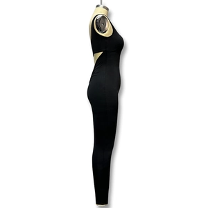 Detail showing the back cutout design and glossy elastic fabric of the black jumpsuit