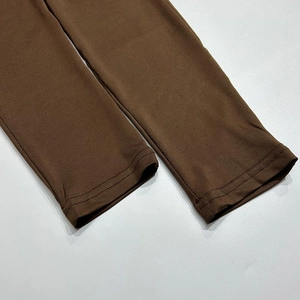 Detail of double-needle stitching on smooth dark brown elastic fabric bodysuit