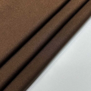 Close-up detail of dark coffee textile fabric showing cotton-linen texture and weaving