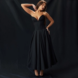 Détails d'une robe longue bustier noire avec taille corsetée structurée et jupe plissée