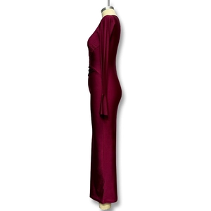 Detail view of the wine red long sleeve dress featuring side pleats and silky satin fabric