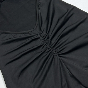 Detailopname van een zwarte yoga jumpsuit met een geplooide V-hals en slanke pasvorm