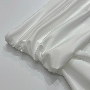 Detail van witte satijnen stof met elegante rimpels en een glanzende afwerking