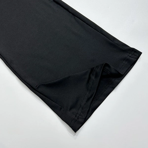 Detailopname van de dubbele naaldsteek en gladde zwarte gebreide stof aan de zoom van kleding
