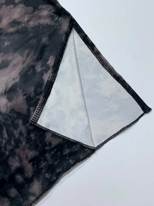 Détail de la fente sur robe à imprimé tie-dye avec finitions de couture surjetées