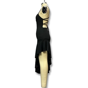 Détail des bretelles croisées et de l'ourlet à volants asymétrique de cette robe noire